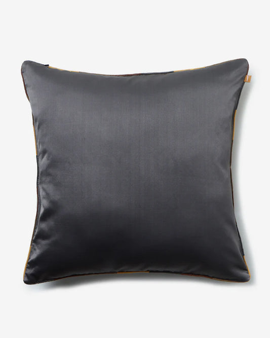 The reverse side of the Gyasar silk pillow showing a smooth, solid charcoal gray silk face with silver piping.