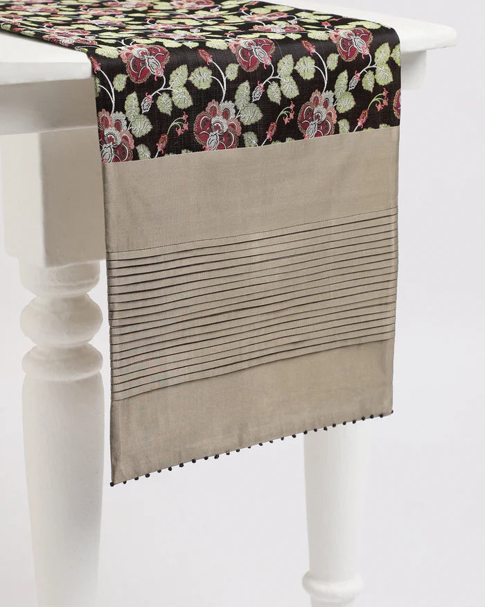 Midnight Garden runner — green and red climbing florals woven into black Tanchoi silk, draped on a table
