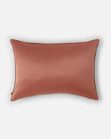 The reverse side of the pillow in a solid, luminous burnished copper silk with a brushed metal glow.