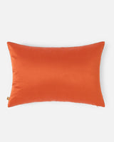 The solid, radiant clementine silk reverse side of the floral Tanchoi pillow.