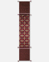 Full-length view of the Hearth runner showing the transition from maroon floral-geometric ikat to black diagonal stripes on rust-red.