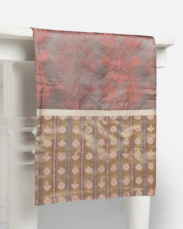 Moonlit Tanchoi silk table runner in dusty rose and mauve, draped over a white ornate table showing the luminous floral damask patterns.