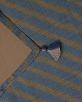Corner detail of the ochre stripe and hand-knotted tassel of silk ikat table runner