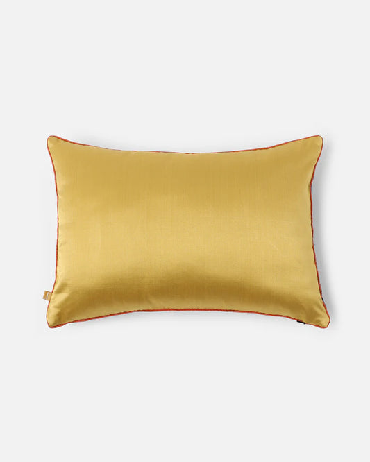 The reverse side of the Midnight Garden pillow showing a smooth, luminous gold silk face with red vermilion piping.