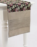 Midnight Garden runner — green and red climbing florals woven into black Tanchoi silk, draped on a table