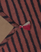 Corner detail of the black border and hand-knotted tassel of ikat silk table runner