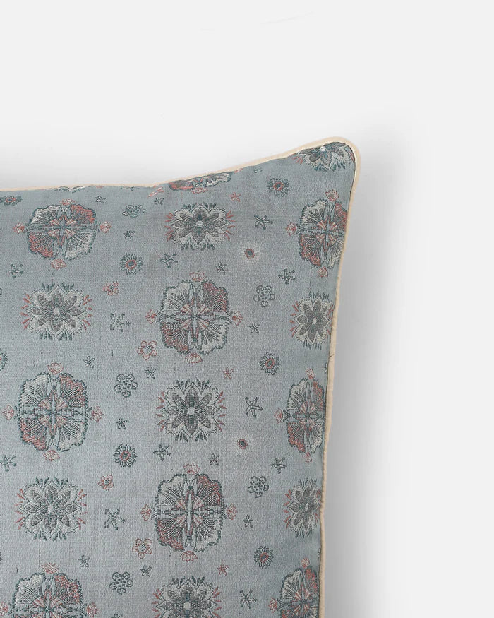 Close detail of floral medallions woven into the powder-blue silk, not printed