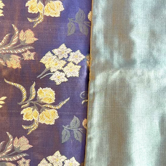 Cinematic reveal of the shimmering silk Tanchoi weave on the Banarasi Botanical pillow, showing the slate blue and seafoam faces.