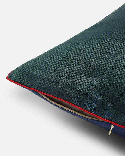 Close-up of the striking red corded piping and premium hidden gold zipper on the edge of the navy and emerald green silk cushion.