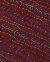 Close detail of vine-and-leaf figuring woven into the red silk, not printed