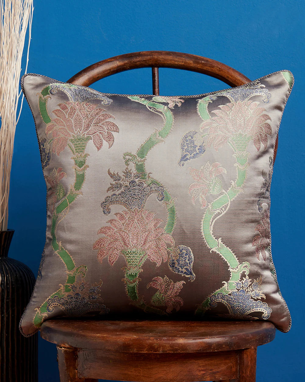 Taupe rose-vine scroll pillow styled on a chair