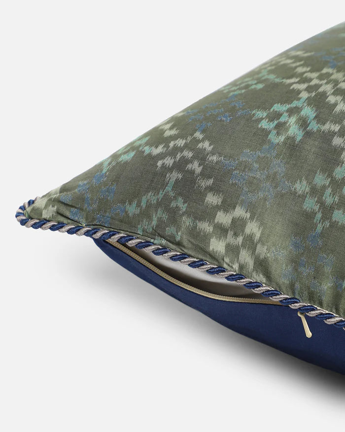 Side view showing sage silk front, navy reverse silk, hidden zip, and navy corded piping