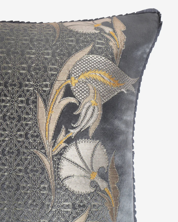 Extreme close-up of the silver geometric lattice silk weave flanked by woven gold-tipped Persian tulip motifs.