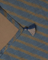 Close-up of the light blue and gold hand-loomed ikat stripes on the Tides ceremonial table silk.