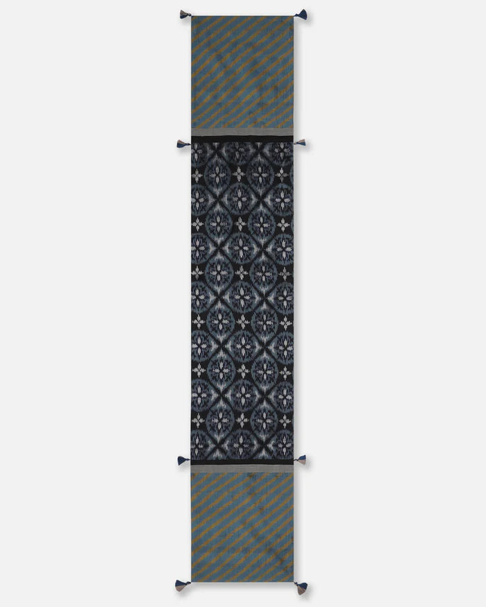 Full view of the 72-inch Tides table runner showcasing the transition between black double ikat motifs and blue striped ends.