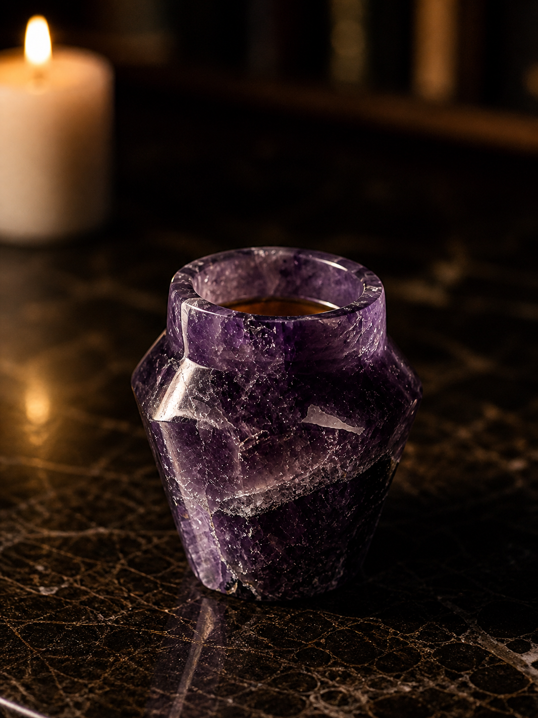 Amethystos shot glass on dark marble in candlelight